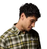 Camisa de franela de manga larga Columbia modelo Cornell Woods, con diseño a cuadros en tonos verde, amarillo y blanco. Cuenta con cuello clásico, cierre frontal con botones y un bolsillo en el pecho con parche de la marca.