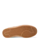 Championes urbanos de diseño clásico con paneles de cuero sintético blanco y detalles en gamuza beige en la puntera y el talón. Presentan una suela de goma color caramelo y cierre mediante cordones al tono.