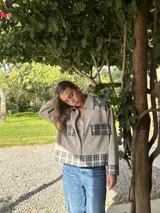 Campera de lana con diseño combinado en color beige liso y paneles a cuadros en tonos grises. Presenta cuello camisero, cierre frontal, bolsillos con solapa en el pecho y puños con detalle a cuadros.