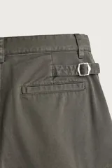 Bermuda cargo color verde militar de corte relaxed fit, confeccionada en tejido de algodón. Cuenta con bolsillos laterales con solapa en las perneras, trabillas en la cintura con ajuste lateral y cierre frontal con cremallera y botón.