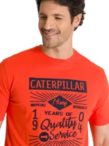 Remera roja de manga corta con cuello redondo y estampado vintage en el pecho con la inscripción "Caterpillar" y texto relacionado a la historia de la marca.