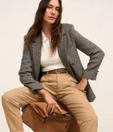 Pantalón mom fit de tiro alto color tostado, con pliegues en la cintura, trabillas para cinturón y bolsillos laterales.