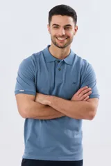 Remera polo de piqué de algodón color azul, de manga corta, con cuello camisero, cierre frontal de dos botones y pequeño logo bordado en el pecho.
