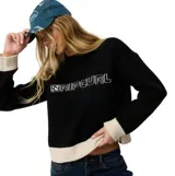 Buzo tejido de punto Rip Curl Archive modelo Script Knit, color negro con detalles en color crudo en el cuello, puños y dobladillo inferior. Presenta el nombre de la marca bordado en el pecho.