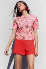 Bermuda roja de tiro alto con bolsillos delanteros de vivo y cierre lateral con cremallera oculta.