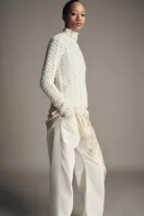 Jersey de punto con cuello subido y manga larga, confeccionado con un diseño de tejido combinado que presenta una textura calada y delicada.