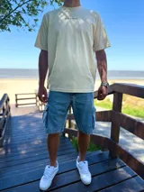 Remera oversize de color beige con estampa en la espalda de una palmera y una tabla de surf, acompañada de la inscripción "Surfer's Paradise Laguna Beach".
