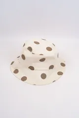 Gorro tipo bucket color crema con estampado de lunares fucsias.