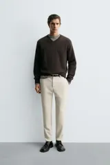 Pantalón de corte slim fit confeccionado en tejido elástico, con cintura elástica, cierre frontal con cremallera y botón, bolsillos laterales y bolsillos traseros de vivo.