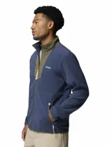 Campera de polar para hombre con cierre frontal completo. Presenta un diseño de bloques de color con cuerpo en azul y detalles en verde oliva en el cuello y la solapa central. Incluye bolsillos laterales con cierre y logo de la marca bordado en el pecho.