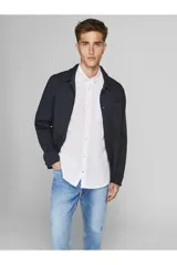 Camisa blanca de manga larga con cuello abotonado, cierre con botones y bolsillo en el pecho.