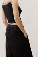 Pantalón de corte ancho y holgado, de color negro, con diseño estructurado y cinturón ajustable integrado en la cintura.