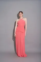Vestido largo de gasa plisada color coral, con cuello halter cruzado y corte imperio.