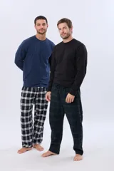 Pijama de hombre compuesto por una remera de manga larga y un pantalón a cuadros. El modelo de la izquierda lleva una remera azul marino y pantalón a cuadros blancos y azul marino. El modelo de la derecha lleva una remera negra y pantalón a cuadros verdes y azul marino.