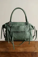 Bolso tote de cuero lavado negro con efecto gastado, interior amplio, bolsillos exteriores con cremallera, dos asas de mano y correa desmontable y regulable.
