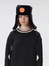 Sweater de punto con diseño de ochos y rombos en color negro, con cuello redondo a la base y detalles en contraste en los rombos. Presenta puños y cuello acanalados.