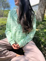 Canguro verde agua a rayas horizontales blancas, de corte amplio, con escote con broches para facilitar la lactancia, bolsillo al frente y puños en mangas y bajo.