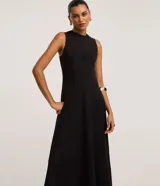 Vestido midi evasé color negro, sin mangas, con cuello redondo y tirantes anchos. Confeccionado en bengalina con costuras verticales decorativas.