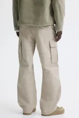 Pantalón cargo de lona de algodón con corte relajado, bolsillos laterales con solapa, bolsillos al bies y pliegues reforzados en las rodillas.