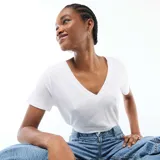 Camiseta básica de manga corta con cuello en pico, confeccionada en tejido ligero de color blanco.