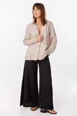 Blazer de lino italiano color beige, de botonadura sencilla, solapas clásicas, bolsillos de parche y detalle de puños tableados.