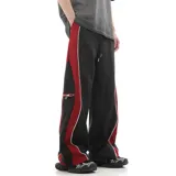 Pantalón deportivo de calce amplio y oversize, color negro con paneles laterales en rojo y vivos blancos que recorren el corte. Posee bolsillo lateral con cierre y cintura regulable.