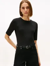 Remera negra de corte slim confeccionada en viscosa sostenible con elastano, con tejido de canalé 5x2. Presenta cuello redondo y mangas 3/4, con un diseño ajustado al cuerpo.
