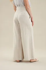 Pantalon de lino color beige de tiro alto, con corte ancho y rectos.
