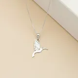 Collar de plata 925 con dije en forma de picaflor, que presenta un ala incrustada en nácar y un pequeño detalle de piedra brillante en el ojo.