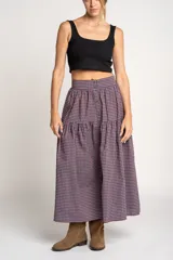 Falda midi de algodón con estampado de cuadros gingham en tonos rosa y azul marino. Tiene corte acampanado, cintura alta y botonadura frontal.