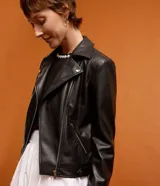 Campera biker negra de cuero sintético con cuello solapa, cierre asimétrico con cremallera, bolsillos con cremallera y mangas largas con detalle de punto roma.