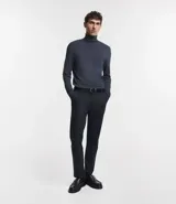 Buzo de corte slim, color negro, con cuello alto y mangas largas, confeccionado en tejido de punto liso.