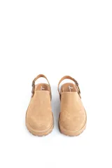 Zuecos de cuero color beige, con suela track y tira trasera ajustable.