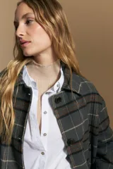 Tapado corto de lana con diseño a cuadros en tonos azul y negro, cuello camisero y cierre frontal con botones.