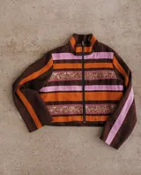 Chaqueta corta con cuello alto y cierre frontal de cremallera. Confeccionada en tejido de lino a rayas horizontales en tonos beige y verde claro, con apliques de galones bordados en tonos dorados y verdes en el pecho y la cintura.