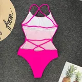 Traje de baño entero negro con escote asimétrico y tirantes blancos trenzados que se cruzan en la espalda.