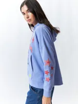 Canguro blanco de manga larga y capucha, con estampa de rayos en tonos rosa, verde y amarillo en el frente y las mangas.