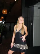 Vestido corto de tela metalizada en tono fucsia con reflejos dorados, con escote en V, diseño de top con triángulos, aberturas laterales en la cintura y doble volado irregular en el ruedo.