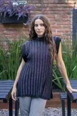 Chaleco tejido de punto acanalado vertical en color negro con hilos de lurex plateados. Presenta cuello redondo, hombros amplios con efecto de hombrera caída y tajos laterales en el ruedo.