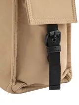 Bolso tipo tote color beige con detalles en negro, confeccionado en lona. Cuenta con doble asa de mano, correa larga ajustable para el hombro, bolsillos laterales con cierre de broche imantado y logo metálico frontal.