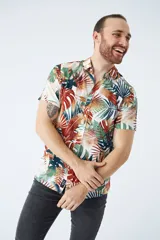 Camisa de manga corta con estampado botánico de hojas en tonos azul y blanco. Presenta cuello clásico, cierre frontal abotonado y corte slim.