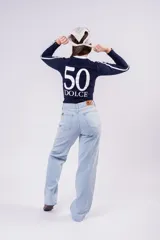 Pantalón de jean corte wide leg en color celeste claro, con tiro medio y diseño de pierna ancha. Presenta cierre frontal con botón y bolsillos laterales.