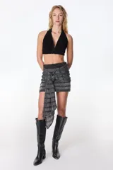 Minifalda color crudo con lurex dorado, diseño cruzado con nudo lateral y corte ajustado.