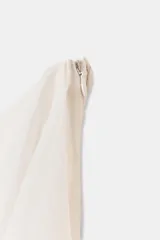 Falda midi de tiro alto, color blanco roto o crema, con múltiples capas de volantes asimétricos que le dan movimiento y textura.