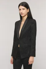 Blazer slim negro con tejido sastrero con lúrex, profundo escote en V, solapa tipo smoking de satén, un botón frontal, bolsillos ojal y tajo en la espalda.