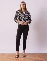 Jean skinny de tiro alto, color azul oscuro, con pretina con pasadores, botón y cierre.