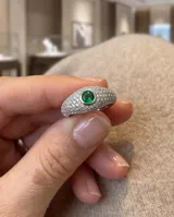 Anillo de plata de diseño abombado, totalmente pavimentado con pequeñas circonitas y engastado con una piedra central redonda de color verde brillante.