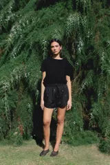 Short negro de algodón con bordados de pequeñas flores rosas y verdes, cuenta con cintura elástica y cordón ajustable.