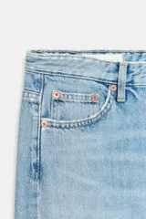 Jeans de tiro medio con diseño de cinco bolsillos y pierna ancha. Presenta un corte recto y holgado con bajo acabado sin costuras y cierre frontal con cremallera y botón metálico.