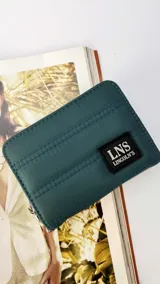 Billetera corta de nylon con diseño capitoneado, cierre perimetral y solapa frontal con logo de la marca LNS Lincoln's. Incluye compartimentos internos para tarjetas, billetes y correa de mano desmontable.